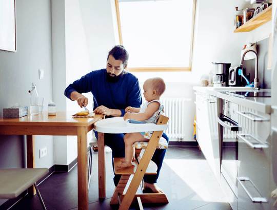 Pai dando refeição ao bebe em uma Cadeira de Alimentação Kiddo 